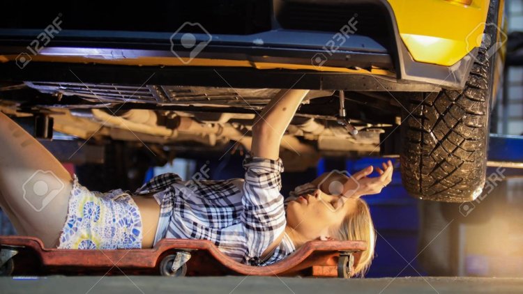 The girl repair the car under the car