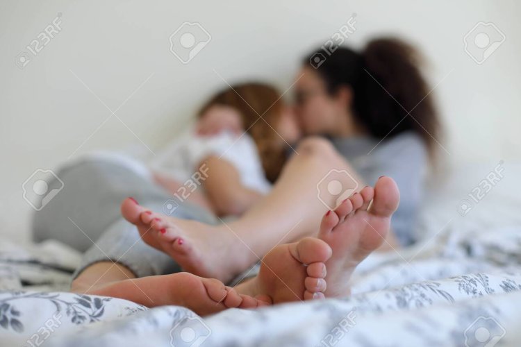 Kiss the legs of a little girl in bed