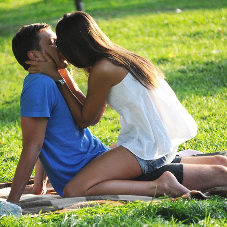 The girl kisses the guy sitting