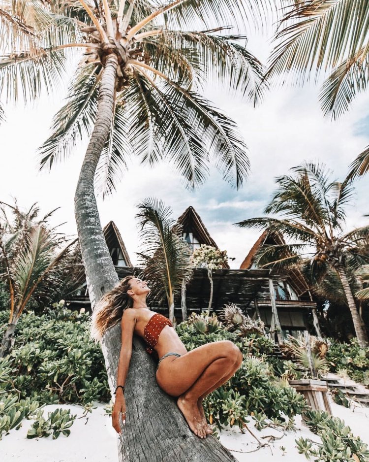 The girl is near the palm tree