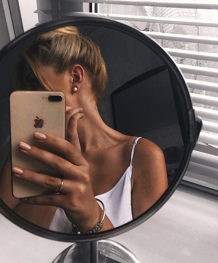 Girl with iPhone in the mirror