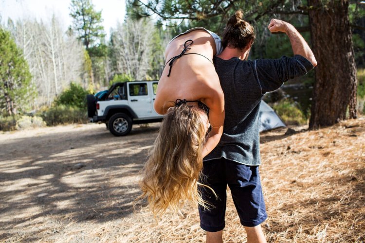 The guy carries the girl on his shoulder