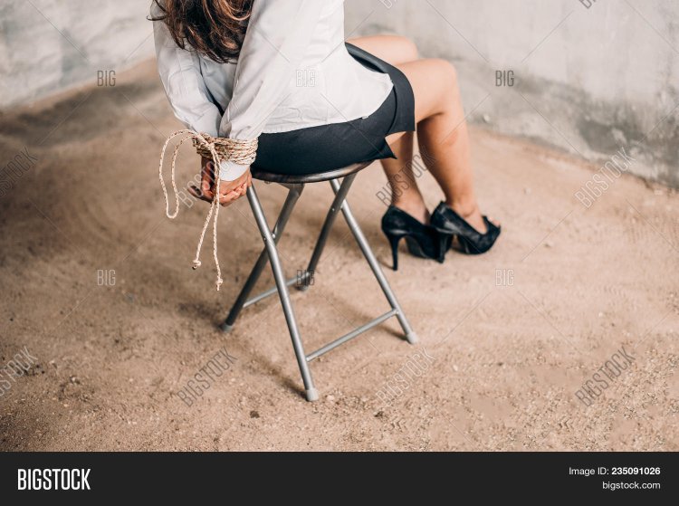 Girl in a dress tied to a chair