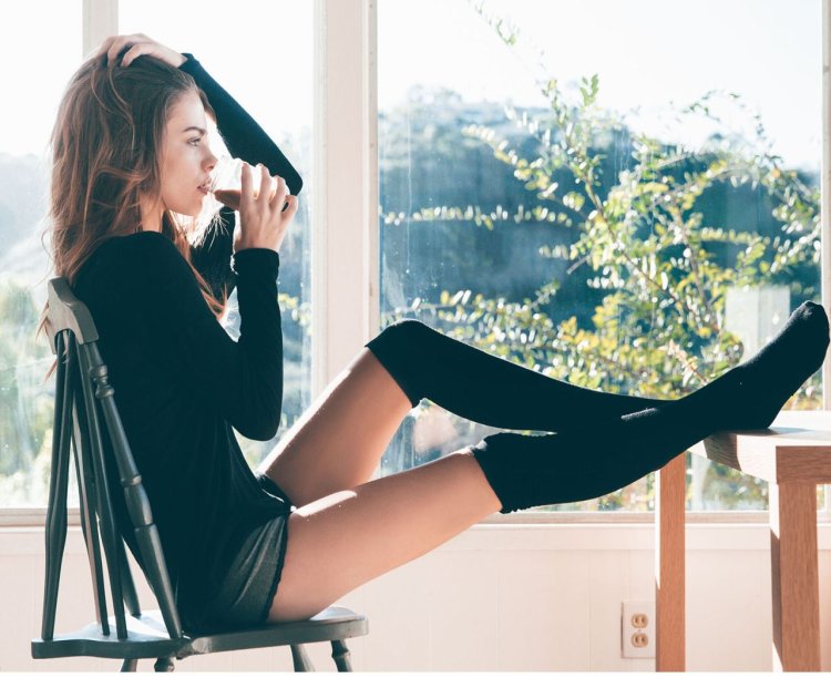 Girl in knee socks on a stool