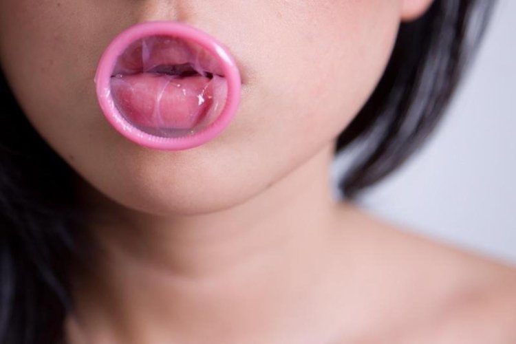 Girl with condom in her mouth