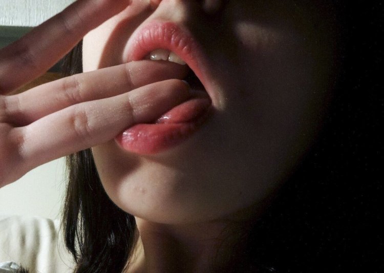 Lips with a finger at the mouth