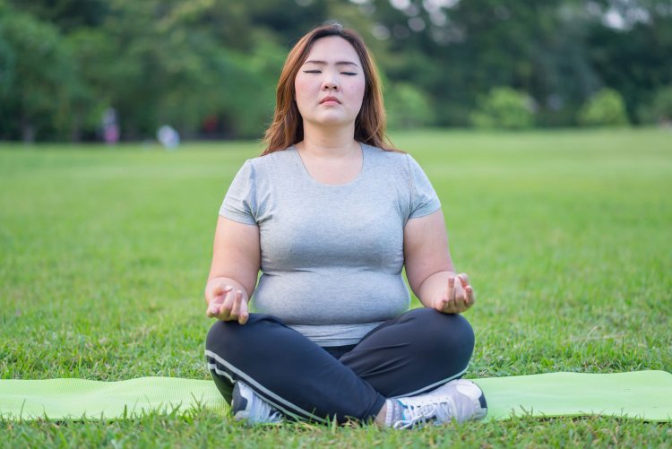 A fat woman is meditating