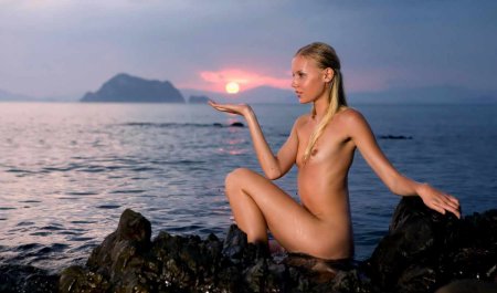 Naked against the background of sunset