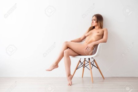 Naked woman sits in a chair